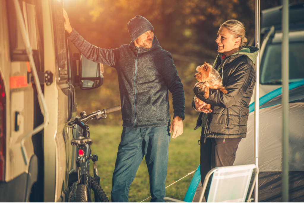 a couple holding their dog in a caravan park